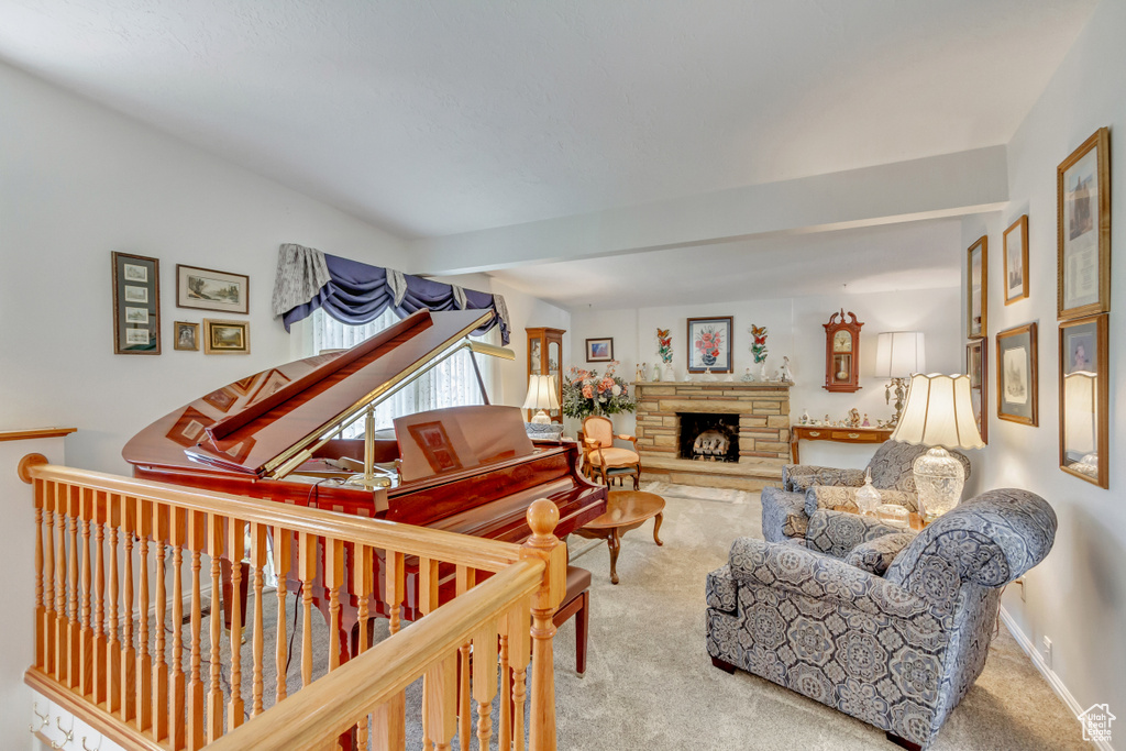 Living room featuring carpet flooring and a stone fireplace