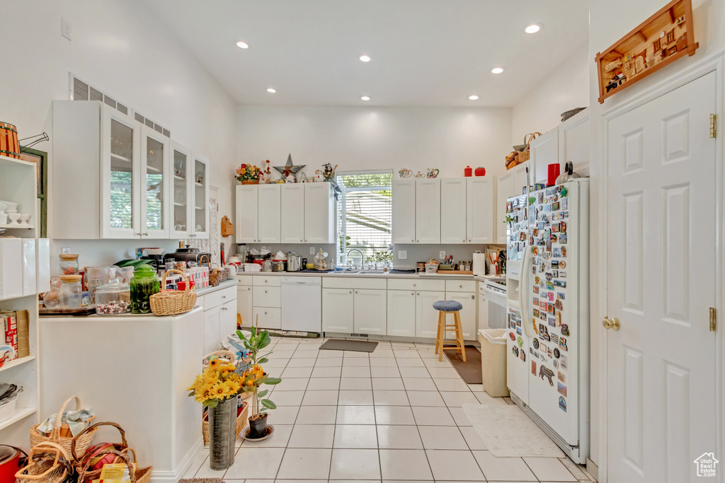 Kitchen with sink, white appliances, white cabinetry, and light tile patterned floors