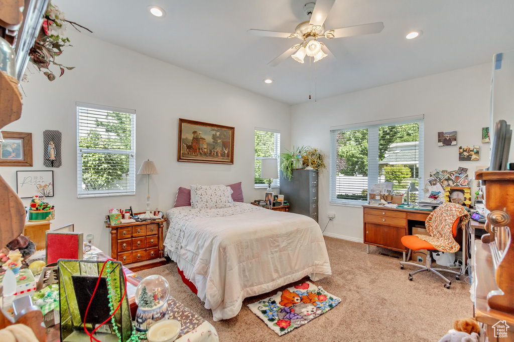 Bedroom featuring multiple windows, light carpet, and ceiling fan