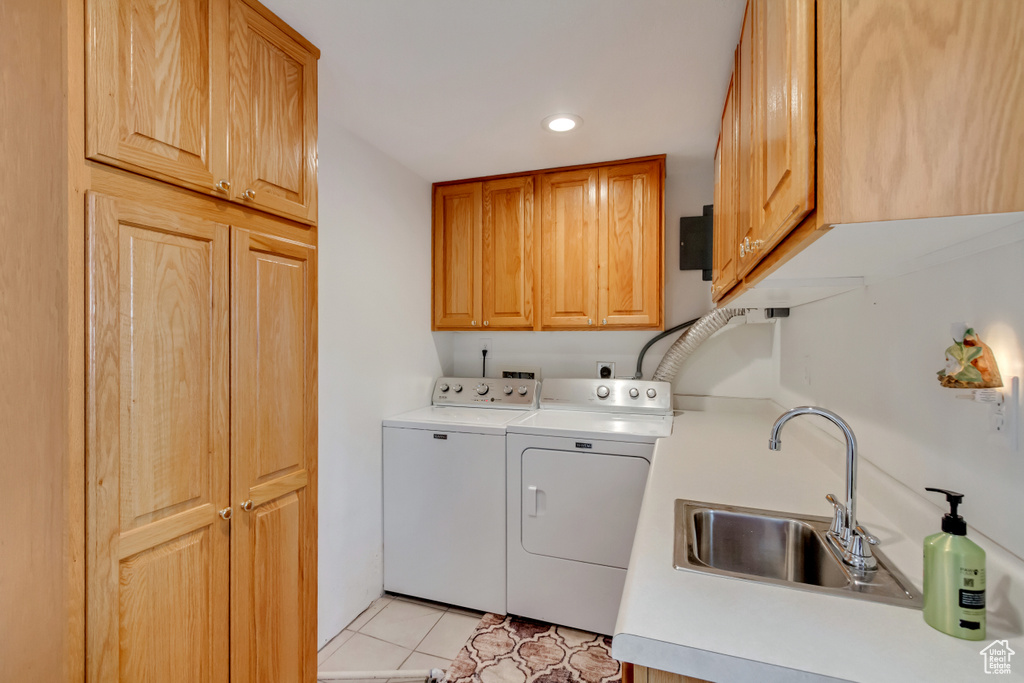 Washroom featuring sink, cabinets, independent washer and dryer, and light tile patterned floors