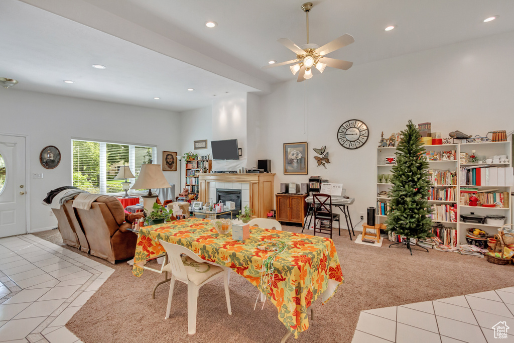 Tiled living room featuring ceiling fan, a tiled fireplace, and a towering ceiling