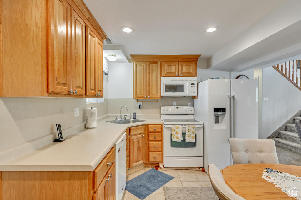 Kitchen with sink, white appliances, and light tile patterned floors