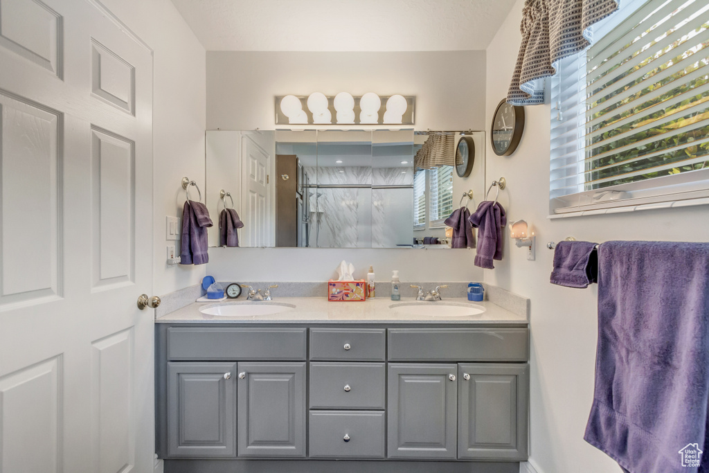 Bathroom featuring a shower with door and vanity