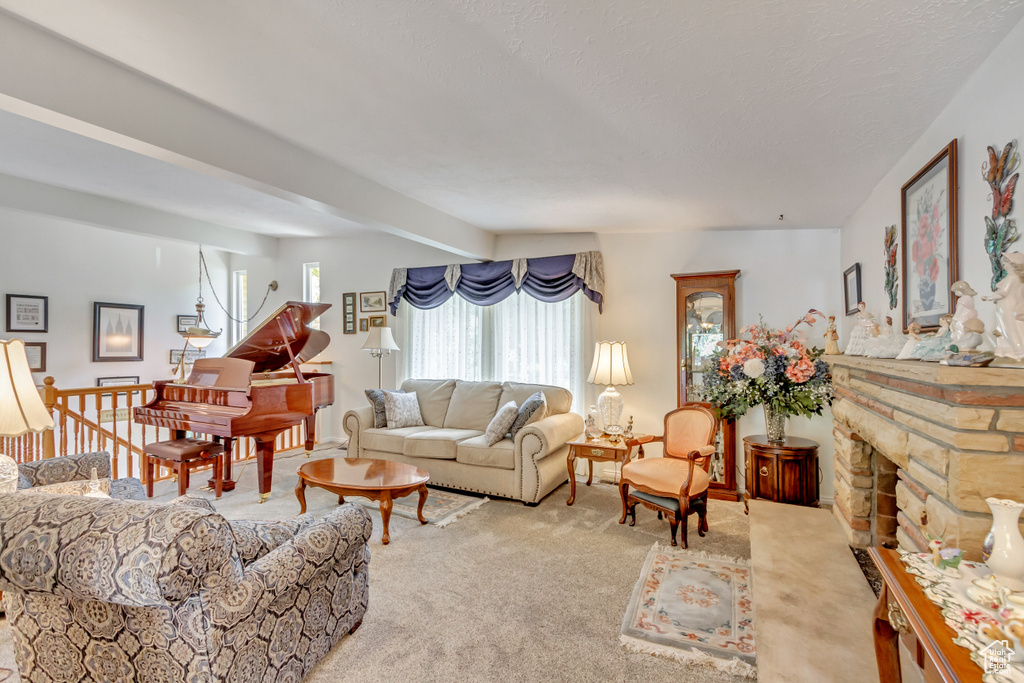 Carpeted living room with a stone fireplace