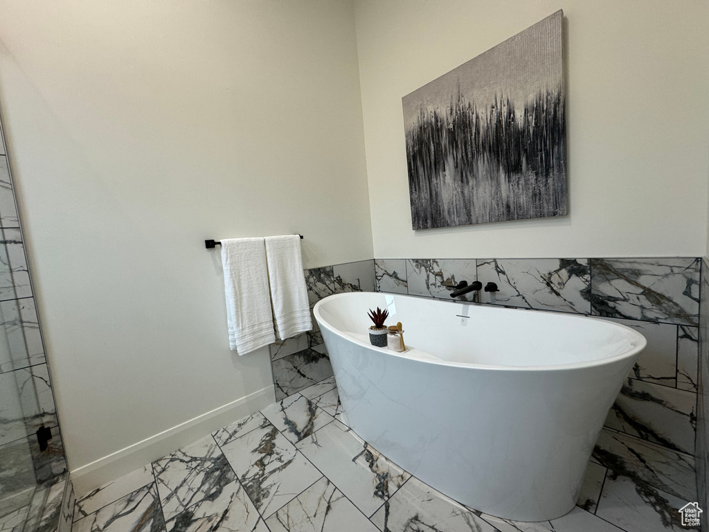 Bathroom featuring a bathtub and tile walls