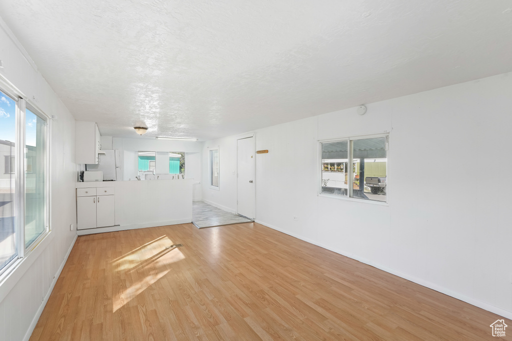 Spare room featuring plenty of natural light and light hardwood / wood-style flooring