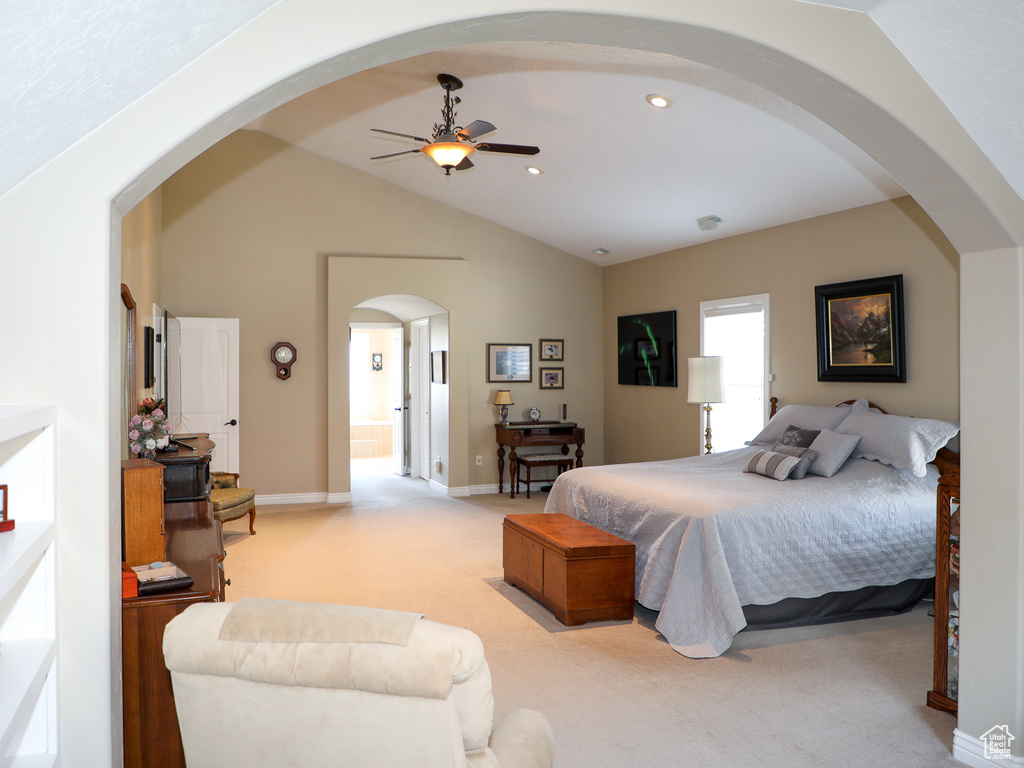 Bedroom with ceiling fan, carpet flooring, vaulted ceiling, and connected bathroom