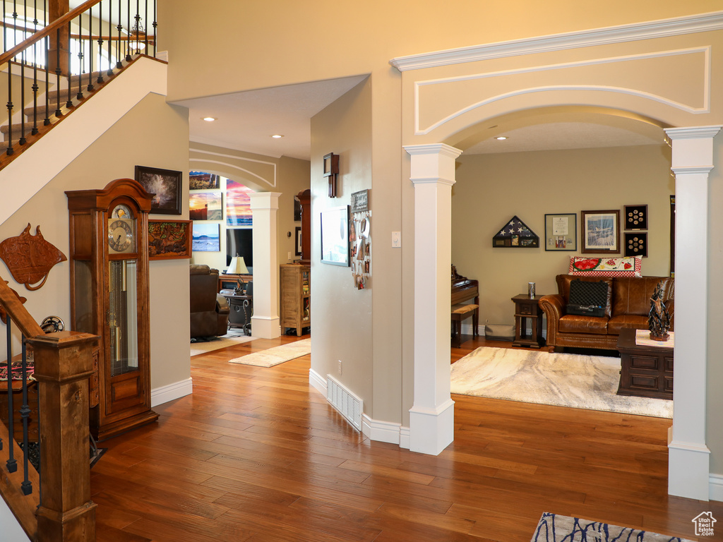 Hallway with hardwood / wood-style floors and decorative columns