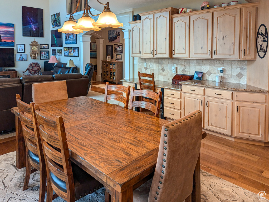 Dining room with a notable chandelier and light hardwood / wood-style flooring