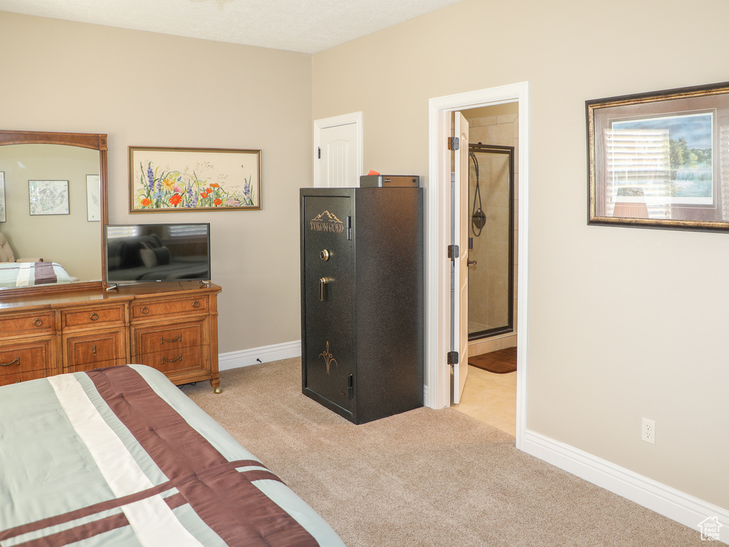 Bedroom featuring light carpet and connected bathroom