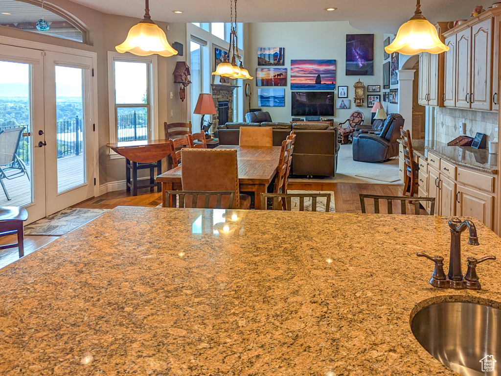 Kitchen featuring sink, hanging light fixtures, light wood-type flooring, and tasteful backsplash