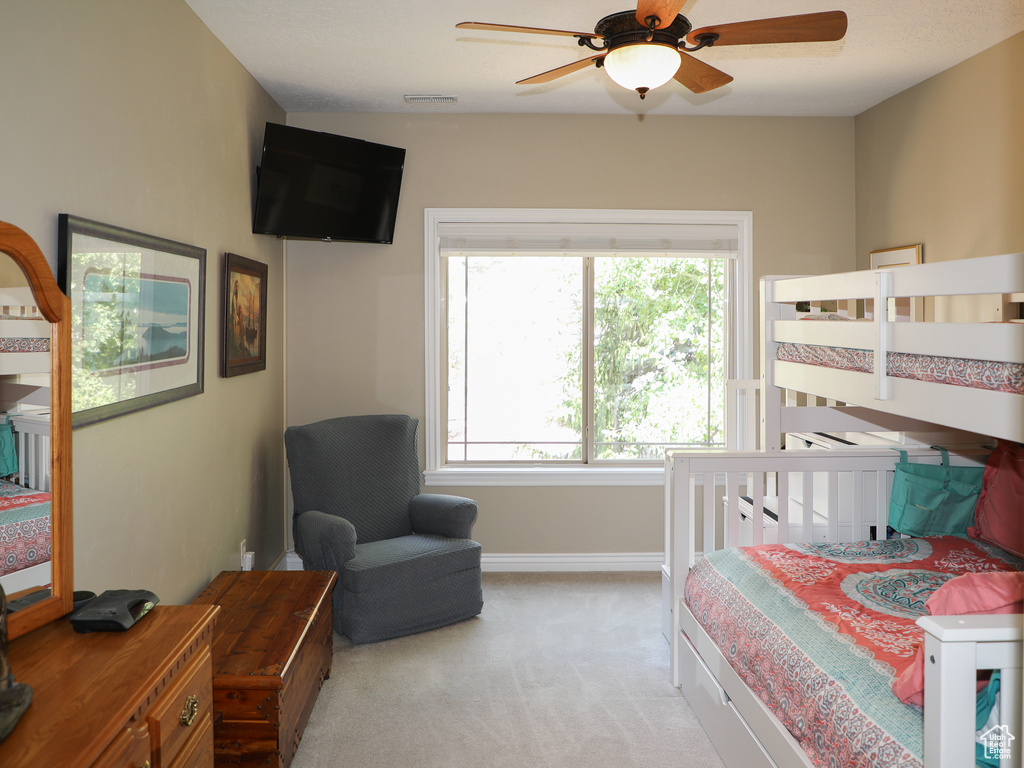 Bedroom featuring multiple windows, ceiling fan, and carpet