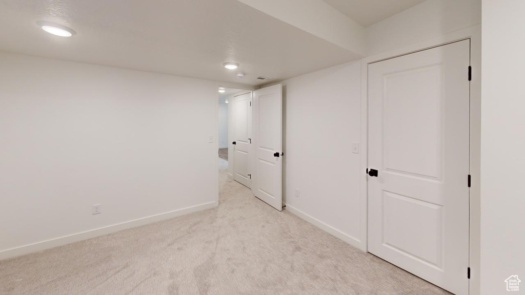 Empty room featuring light colored carpet