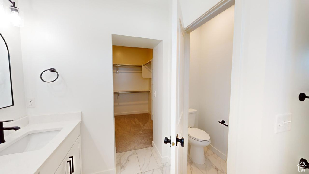 Bathroom with vanity, toilet, and tile patterned floors