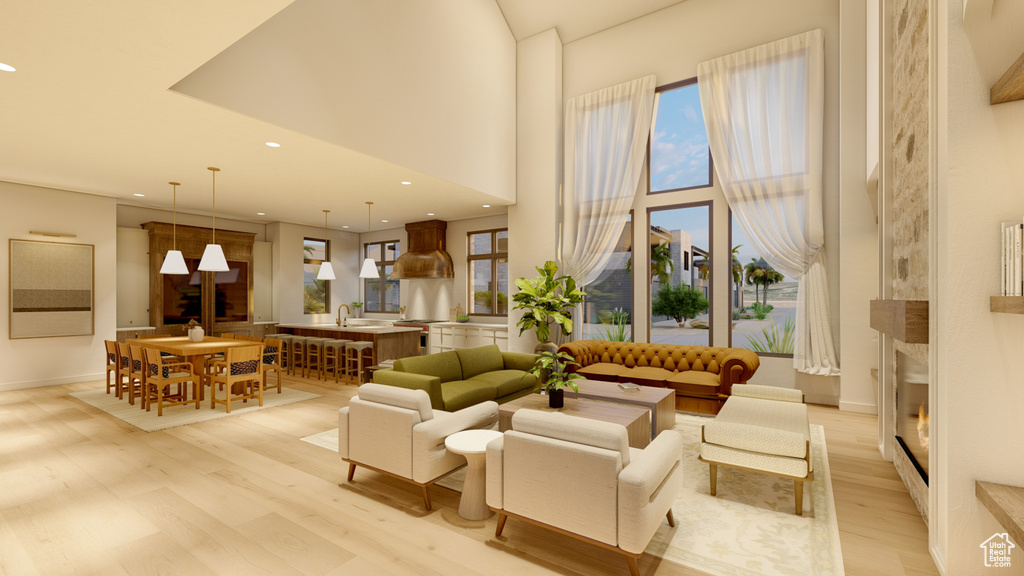 Living room with light hardwood / wood-style flooring and a high ceiling