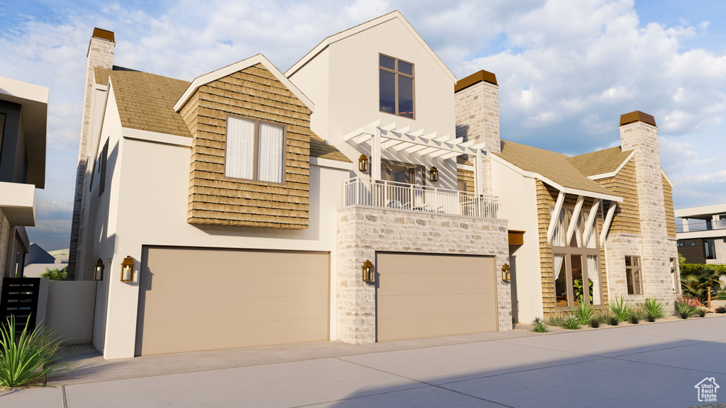 View of front facade featuring a balcony and a garage