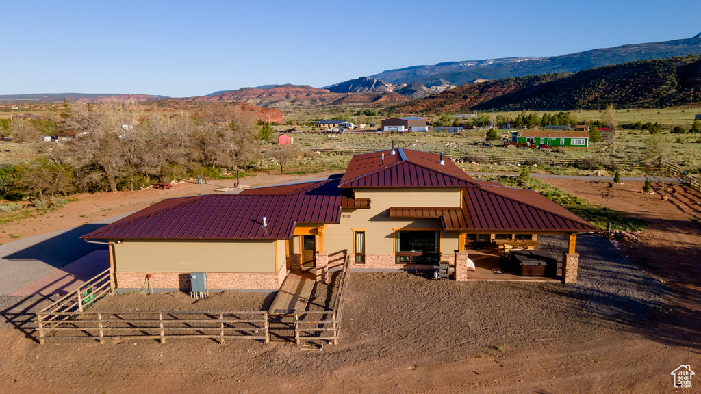 View of front of home with metal roof, a mountain view, a rural view, and fence