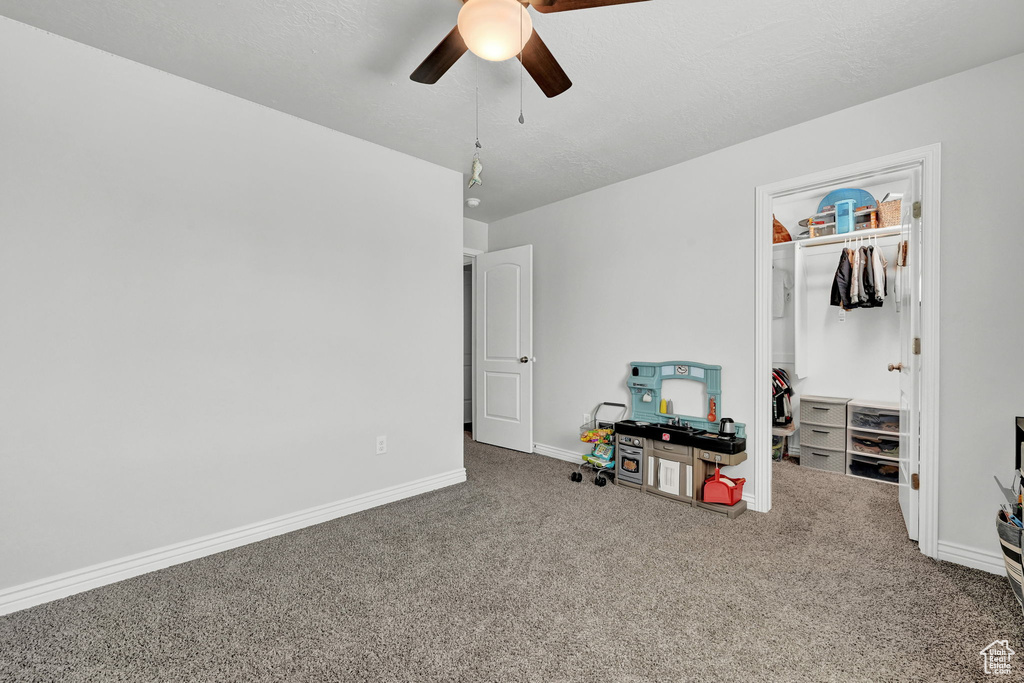 Interior space with ceiling fan and carpet floors