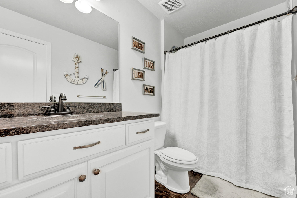 Bathroom featuring vanity, toilet, and tile patterned floors