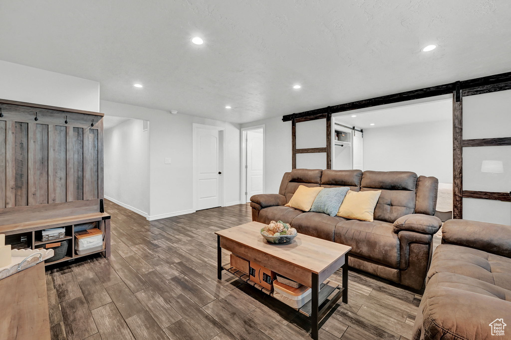 Living room featuring a barn door and dark hardwood / wood-style floors