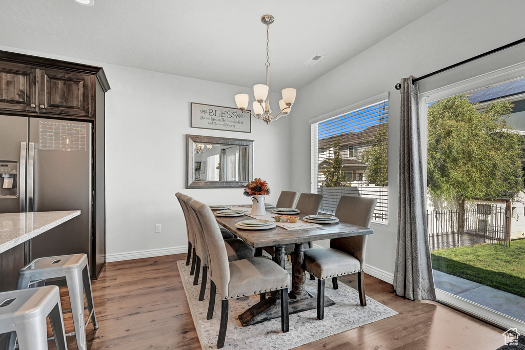 Dining space with dark wood-type flooring and a notable chandelier