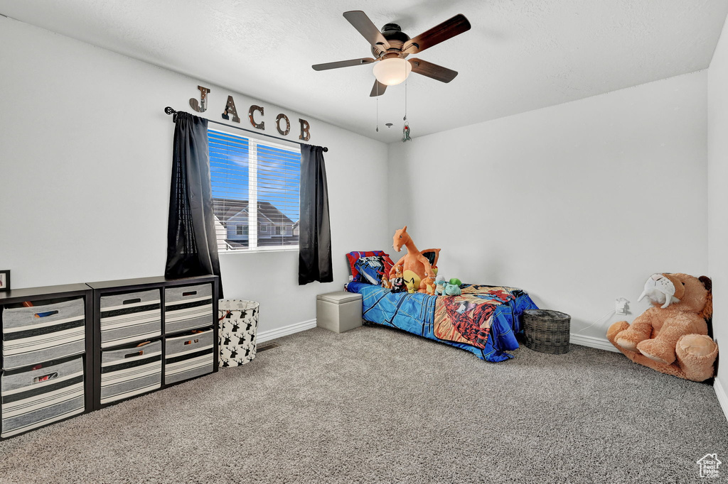 Carpeted bedroom featuring ceiling fan