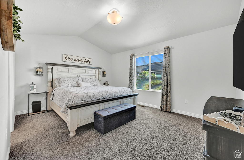 Bedroom with vaulted ceiling and carpet floors