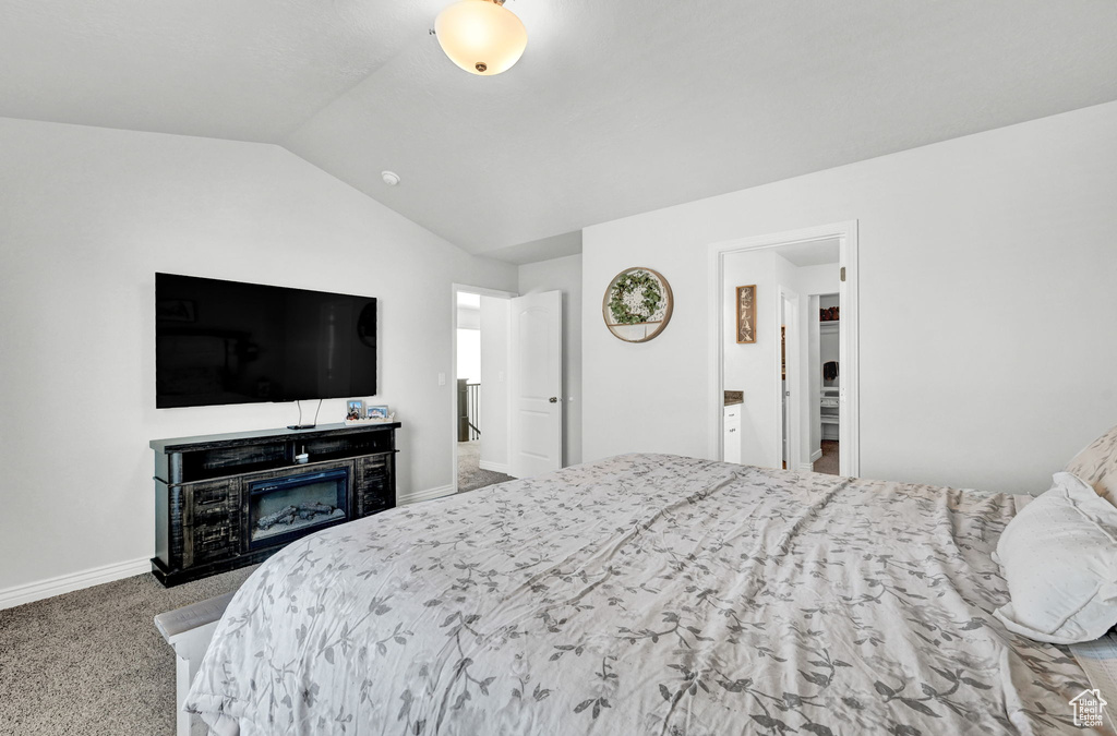 Bedroom with light carpet and lofted ceiling