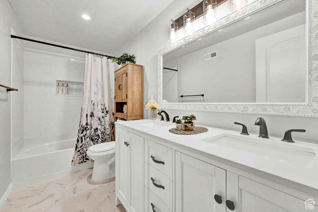 Full bathroom with vanity, toilet, tile patterned floors, and shower / bath combo with shower curtain