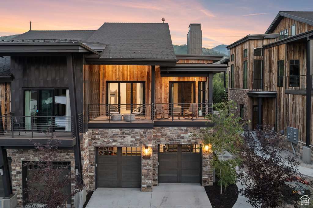 View of front of property featuring a balcony and a garage