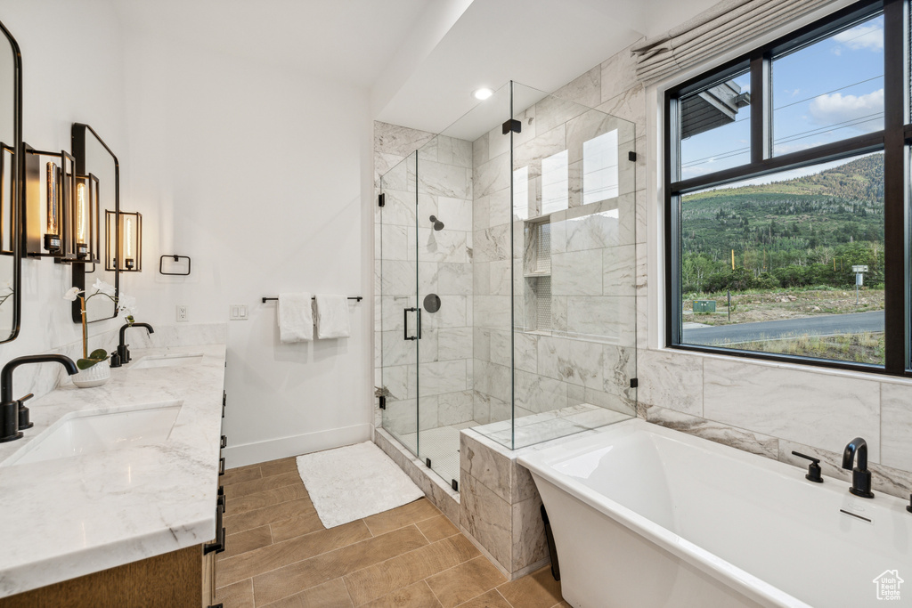 Bathroom with plus walk in shower, tile walls, tile patterned flooring, and vanity