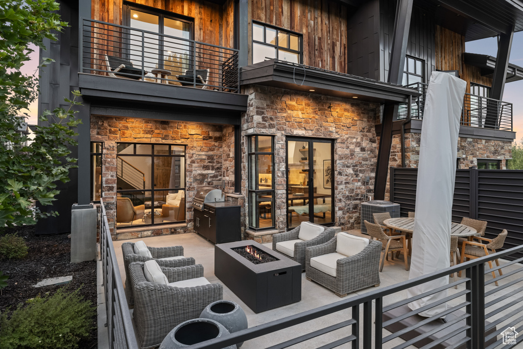 View of patio / terrace featuring a balcony and an outdoor living space with a fire pit