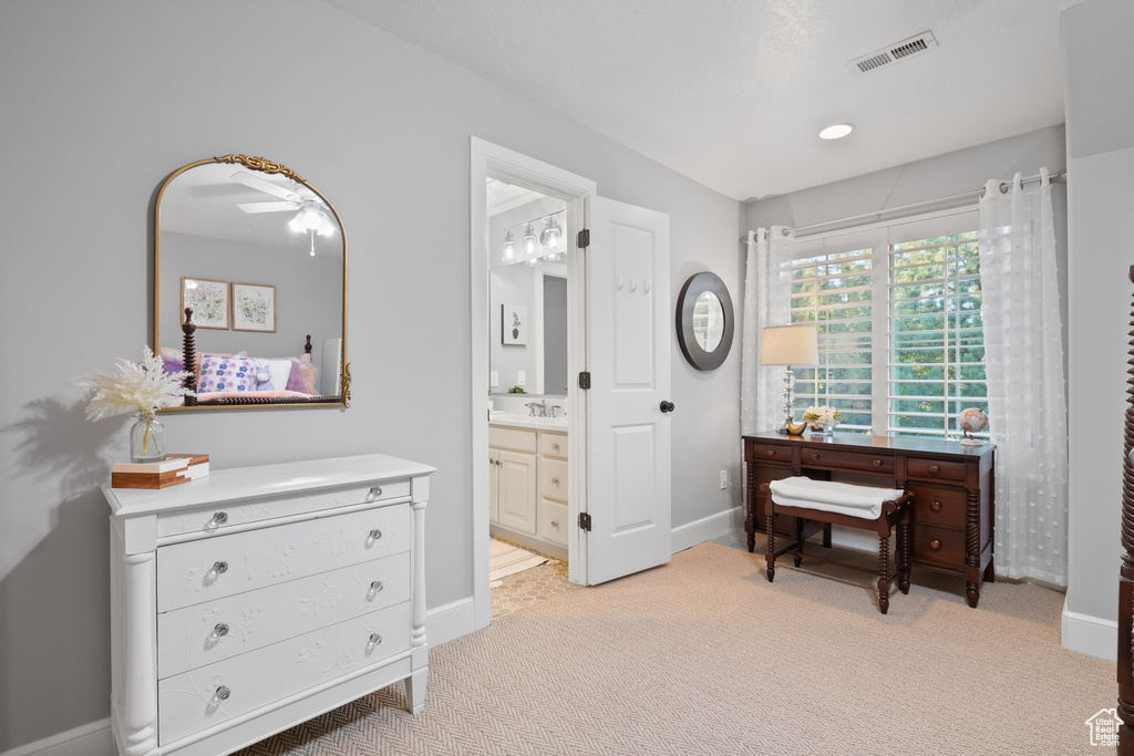 Interior space with ceiling fan, light colored carpet, and sink