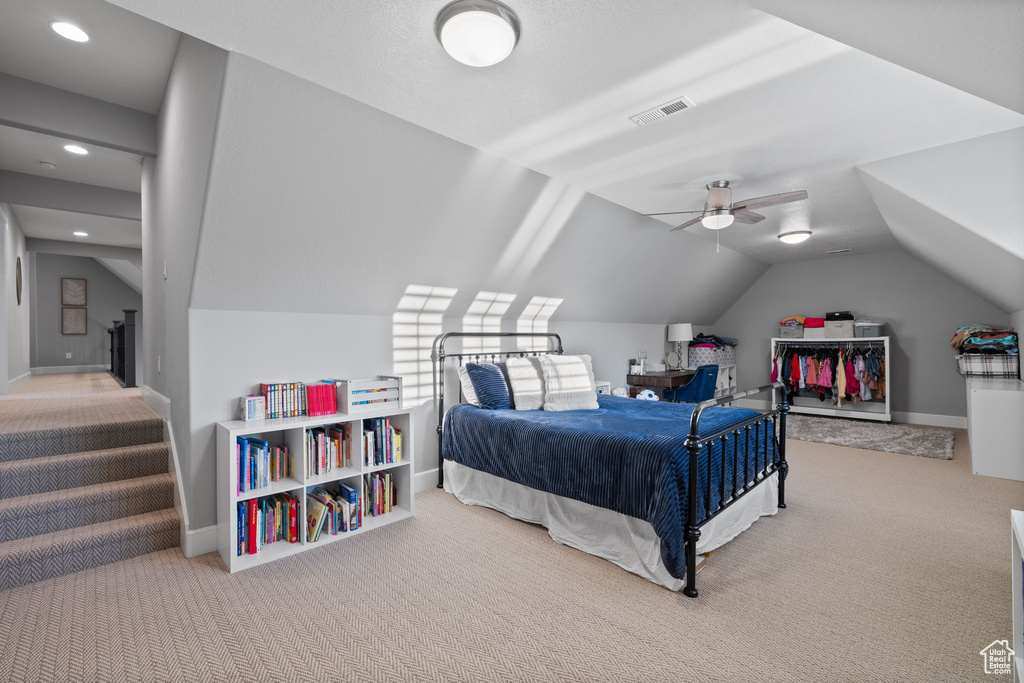 Bedroom featuring vaulted ceiling, ceiling fan, and carpet flooring