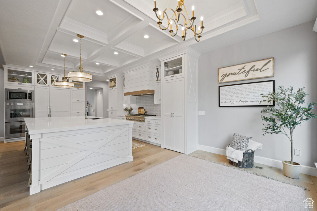 Kitchen featuring white cabinets and hanging light fixtures