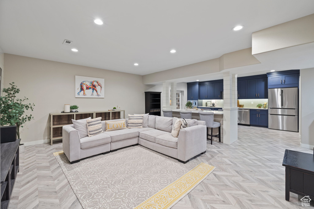 Living room featuring light parquet flooring and decorative columns