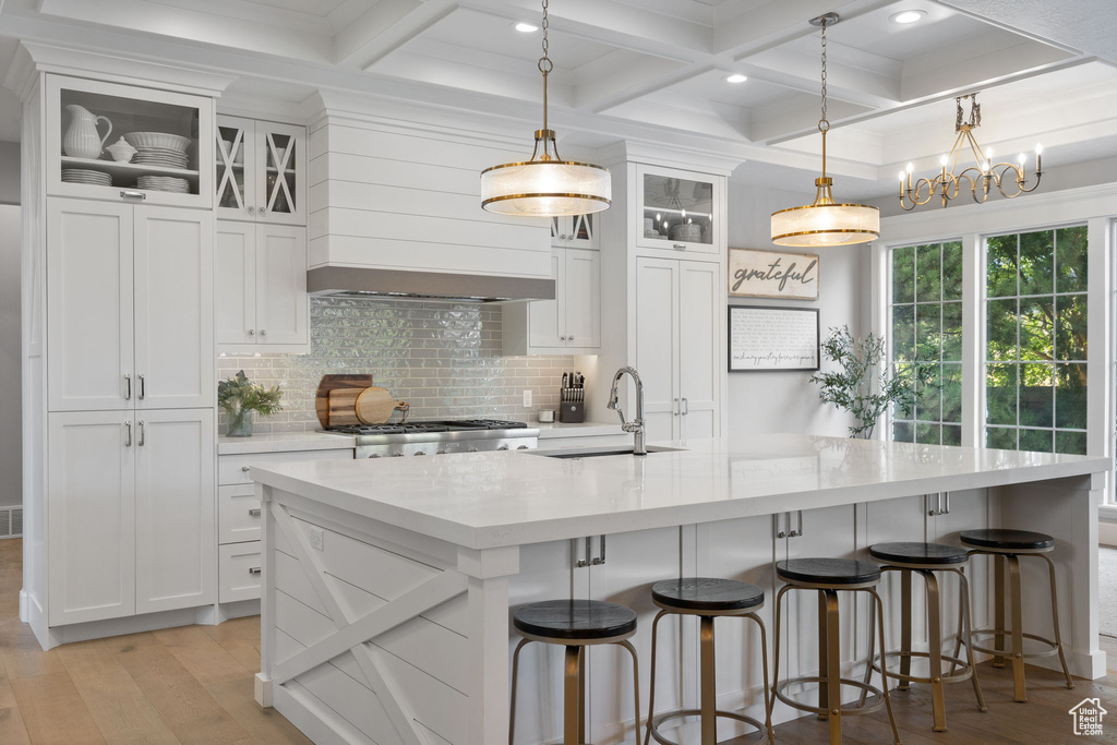 Kitchen featuring sink, pendant lighting, and white cabinets