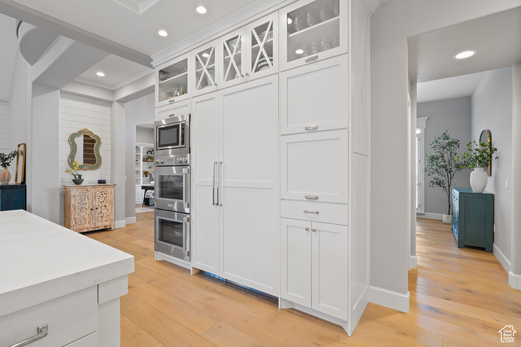 Kitchen featuring light hardwood / wood-style floors, stainless steel appliances, and white cabinets