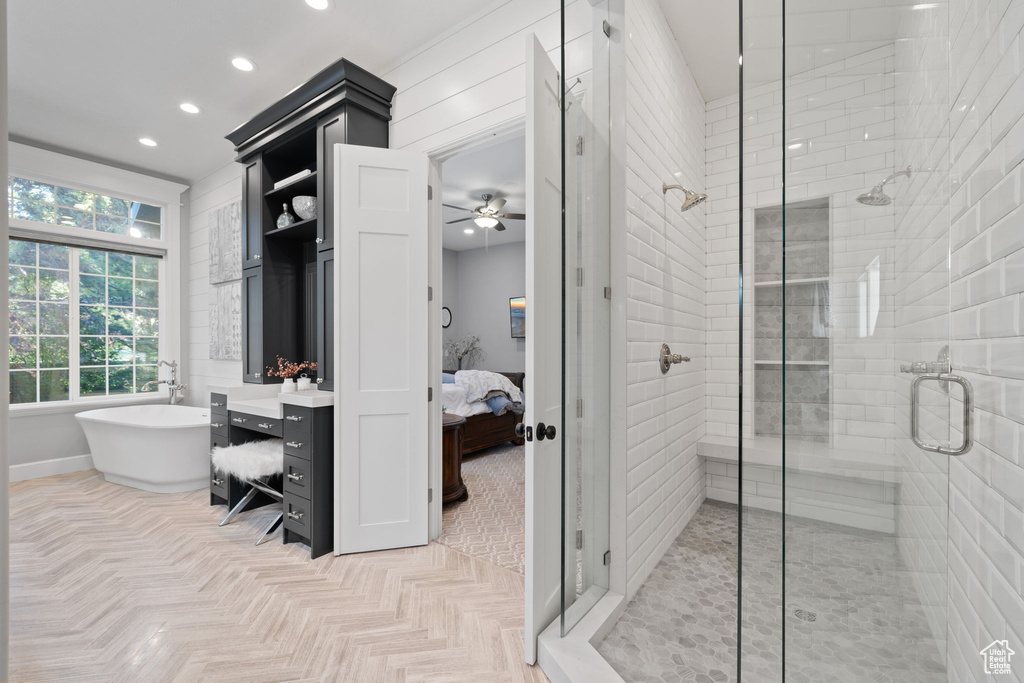 Bathroom featuring vanity, separate shower and tub, and ceiling fan