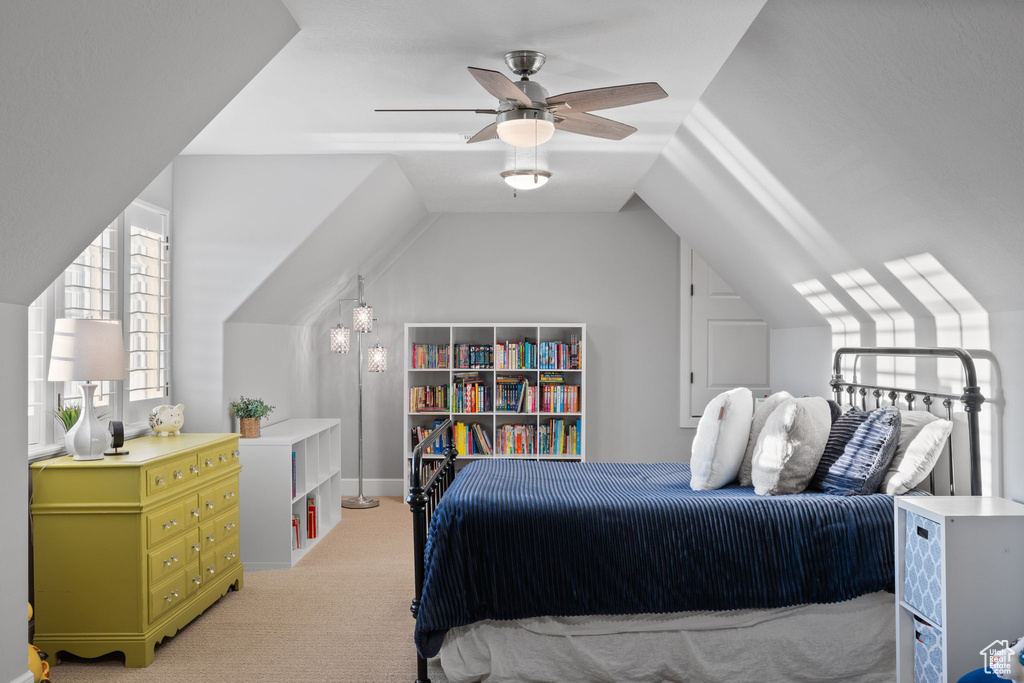 Carpeted bedroom with vaulted ceiling and ceiling fan