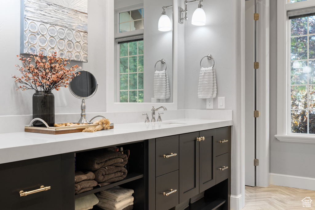 Bathroom with a healthy amount of sunlight, vanity, and parquet flooring