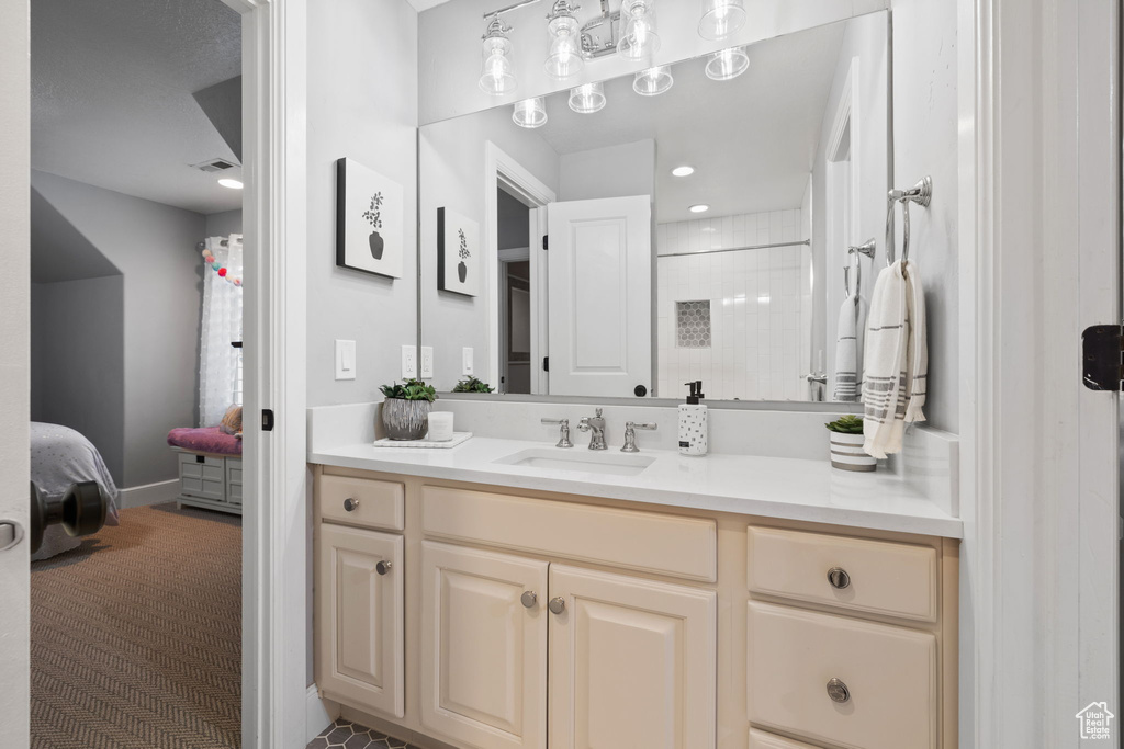 Bathroom with a shower with shower curtain and vanity