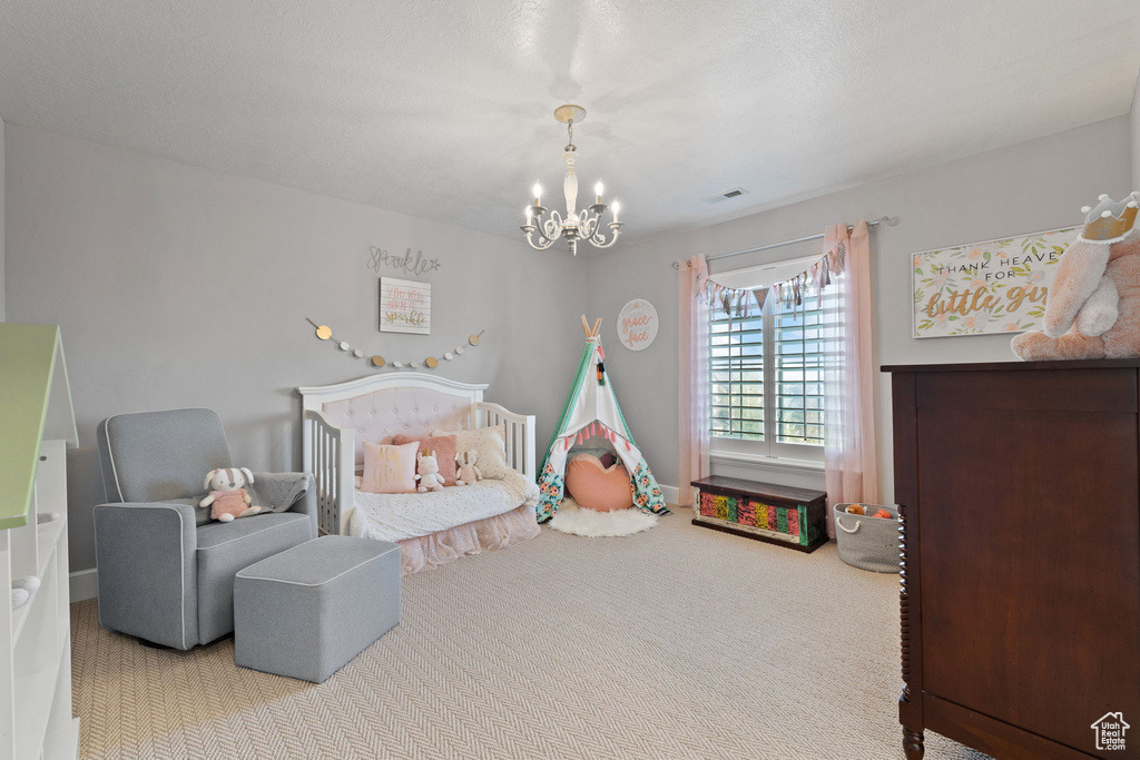 Carpeted bedroom featuring a chandelier