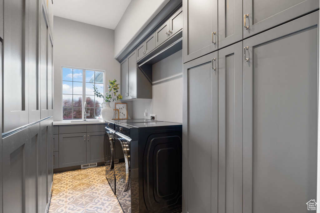 Laundry area featuring cabinets, sink, and independent washer and dryer