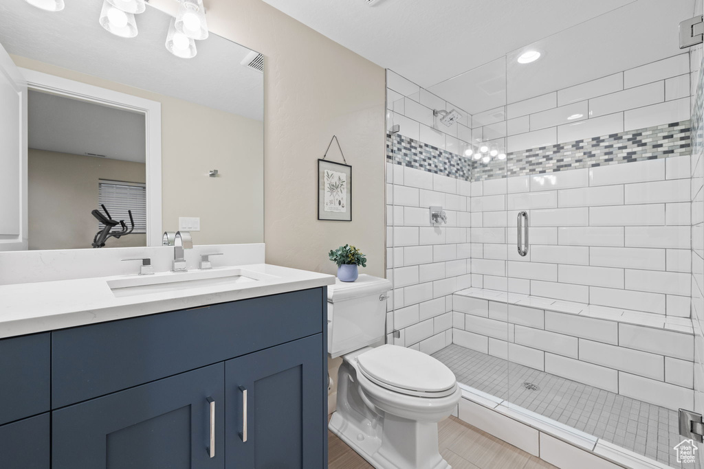 Bathroom featuring walk in shower, vanity, toilet, and tile patterned floors