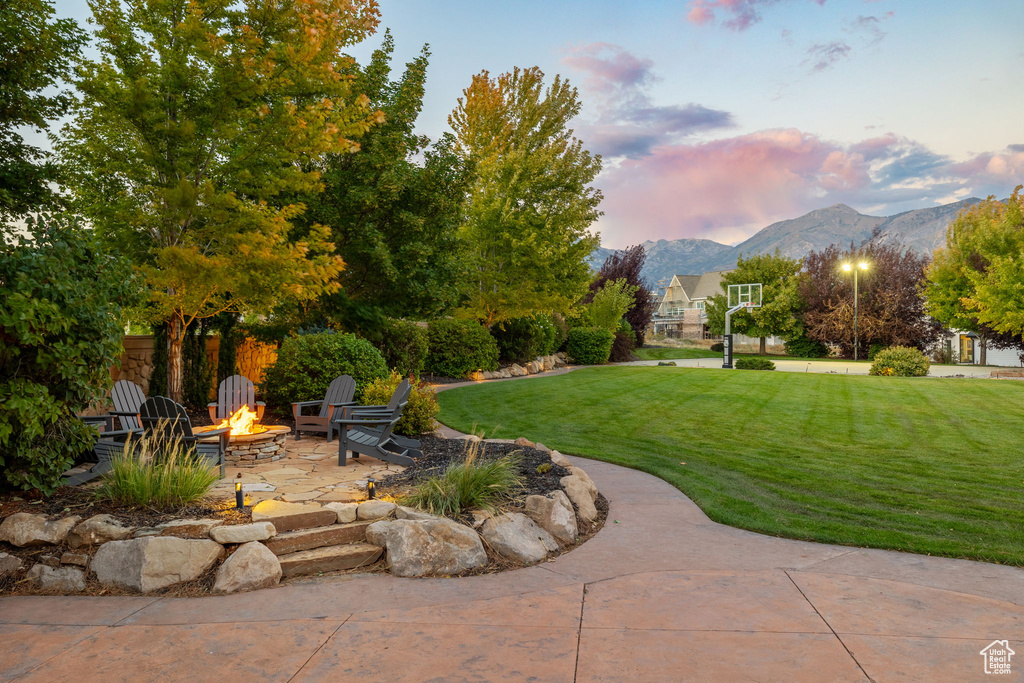 Yard at dusk with a mountain view and an outdoor fire pit