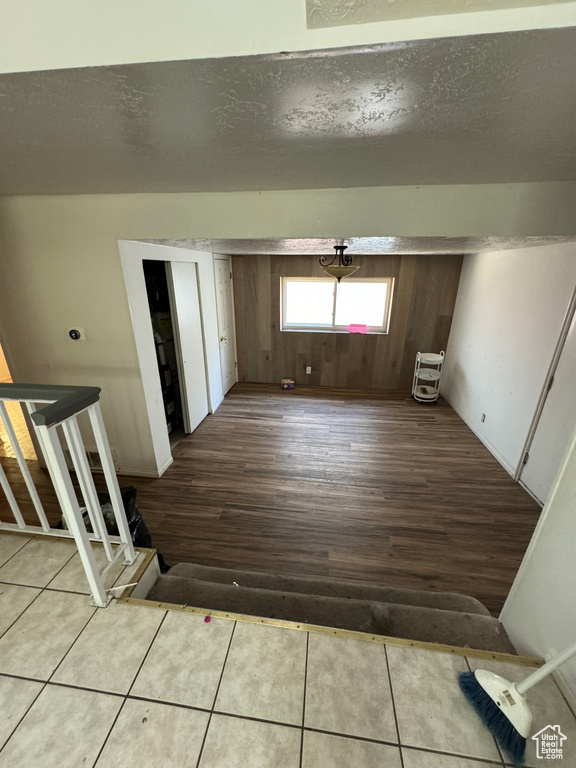 Interior space featuring a textured ceiling, hardwood / wood-style floors, and wooden walls