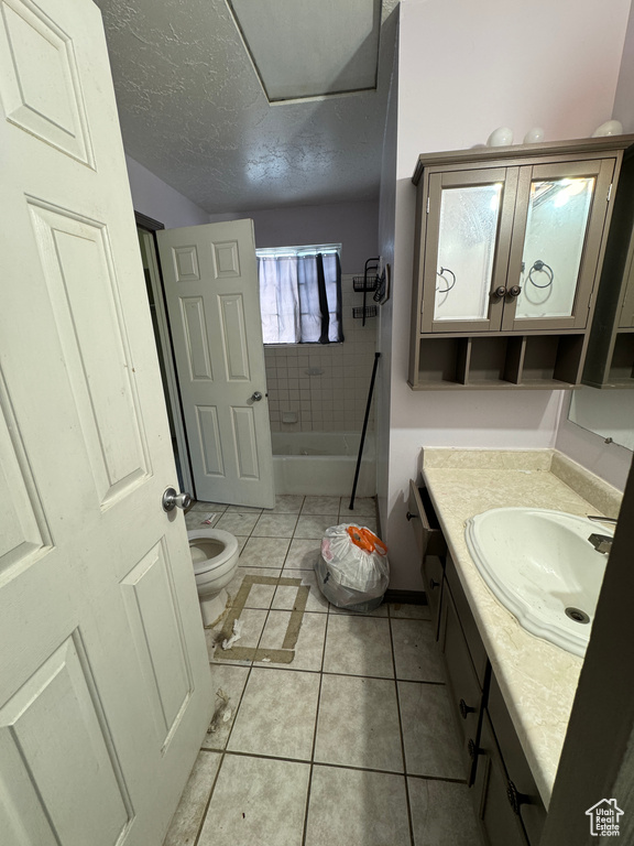 Bathroom with tile patterned floors, toilet, a textured ceiling, and vanity