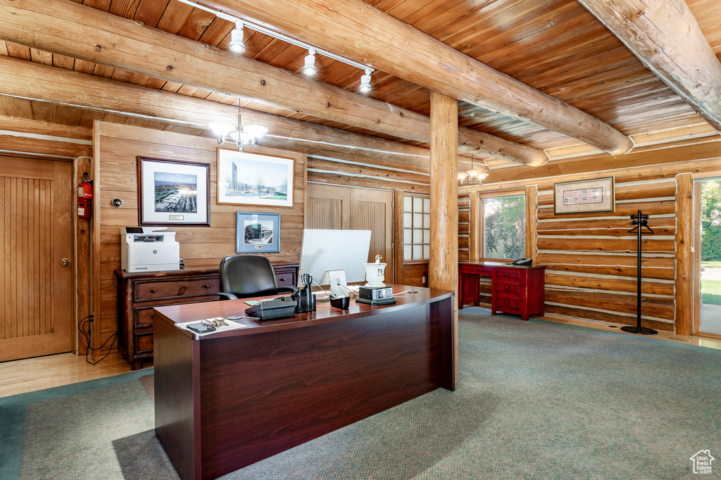 Carpeted office with log walls, wood ceiling, a notable chandelier, rail lighting, and beam ceiling