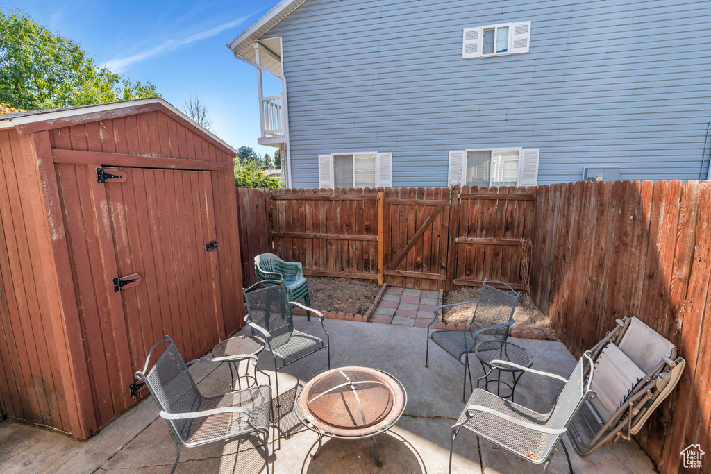 View of patio / terrace with a fire pit and a storage unit